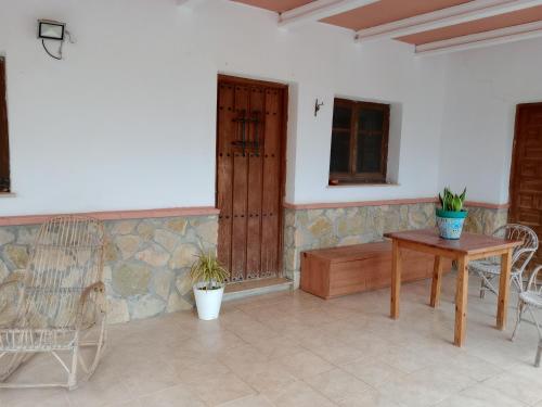 a patio with a table and chairs and a door at CUEVA EL TARAHAL privada y piscina compartida in El Tarahal