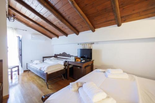 a bedroom with two beds and a desk with a computer at Castello di Haria in Kaloú