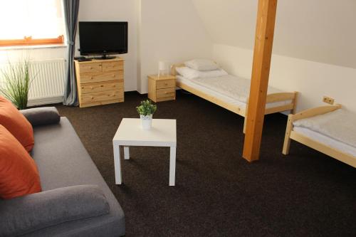 uma sala de estar com um sofá, uma cama e uma mesa em Hostinec a Penzion Staré Nádraží em Ostrava