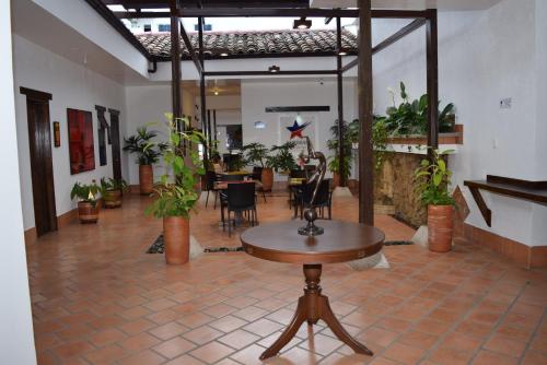 una stanza con tavolo, sedie e piante di Chrisban Hotel Boutique a Buga