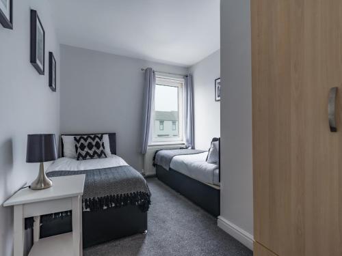 niewielka sypialnia z 2 łóżkami i oknem w obiekcie Haw thorn House - 2 bedroom, Ashington, Northumberland w mieście Ashington