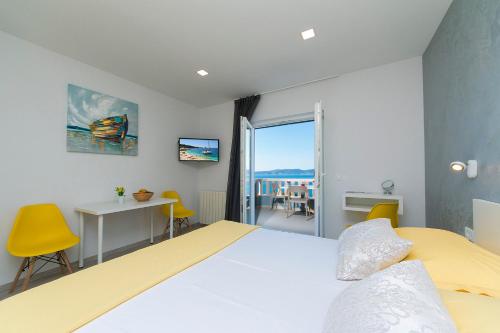 um quarto com uma cama, uma secretária e uma janela em Apartments Vila Nadalina Delux em Brela