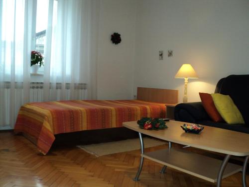 Apartment Horvat في زغرب: غرفة بسرير واريكة وطاولة