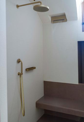 a bathroom with a bench and a shower stall at La Sommità Relais & Chateaux in Ostuni
