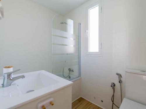a white bathroom with a sink and a shower at Bungalow GARMAS in Maspalomas
