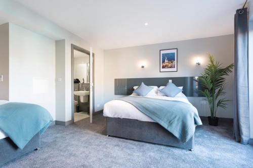 a bedroom with a large bed and a bathroom at Bank Square Town House in Belfast