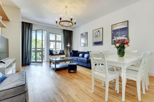 Grand Apartments في سوبوت: غرفة معيشة مع طاولة بيضاء وأريكة
