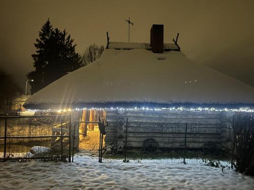 a church covered in snow with lights on it at Pirtiņa in Ogre