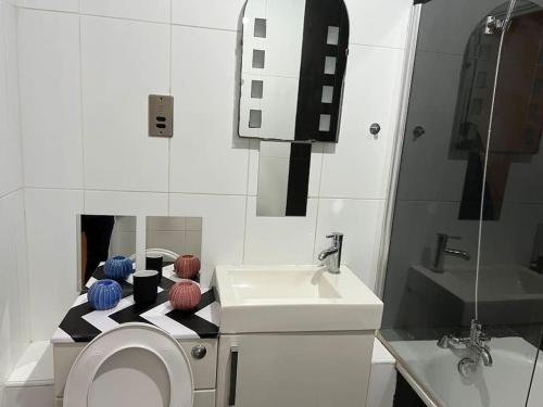 een witte badkamer met een wastafel en een toilet bij Cosy Entire Apartment in WhiteChapel/Commercial Rd in Londen