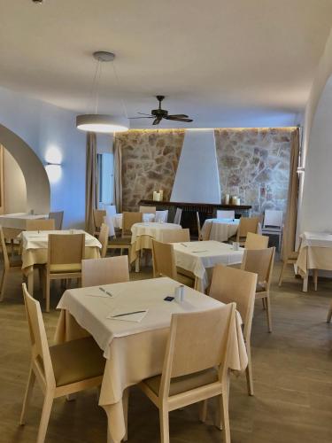 a dining room with white tables and chairs at Hotel Tagomago in San Antonio Bay