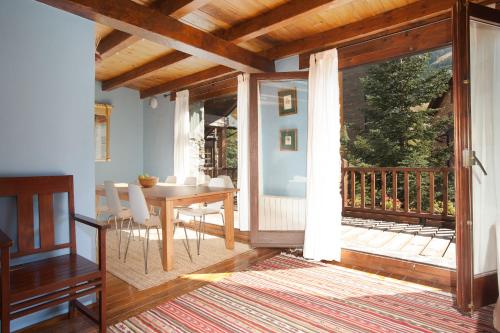 a dining room with a table and a balcony at Tarter Chalets Apartaments in El Tarter