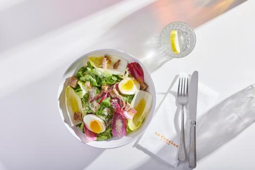 a bowl of salad with eggs and vegetables on a table at Port Tower by Isrotel Design in Tel Aviv