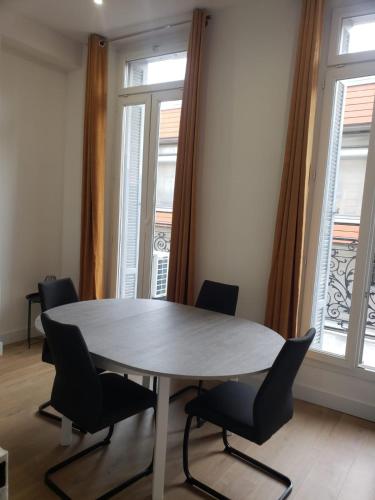une table et des chaises dans une pièce avec des fenêtres dans l'établissement T2 neuf tout équipé, climatisé, à Marseille