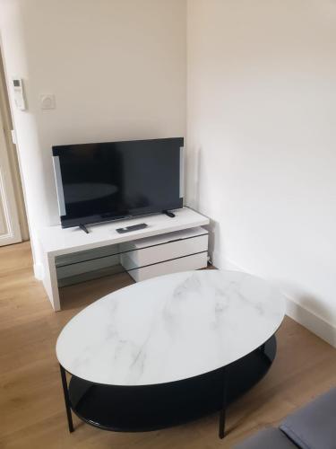- une table basse blanche dans le salon avec une télévision dans l'établissement T2 neuf tout équipé, climatisé, à Marseille