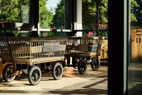 two wicker shopping carts sitting in front of a window at Spa & Resort Bachmair Weissach, LUXURY FAMILY RESORT in Rottach-Egern