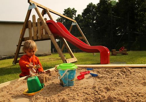 a young child playing in a sandbox in a sandbox at Penzion Zámek Rozsochatec in Rozsochatec