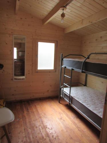 um quarto com um beliche num chalé de madeira em Camping Hoces de Mira em Mira