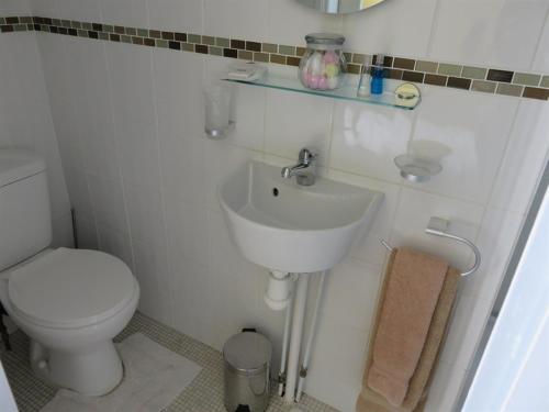 a white bathroom with a toilet and a sink at Oakwell Guest House in Bridlington