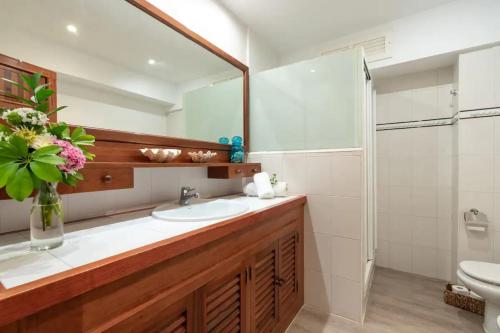 y baño con lavabo, aseo y espejo. en Apartamento Bel Planta Baja First Line Pinewalk, en Puerto Pollensa