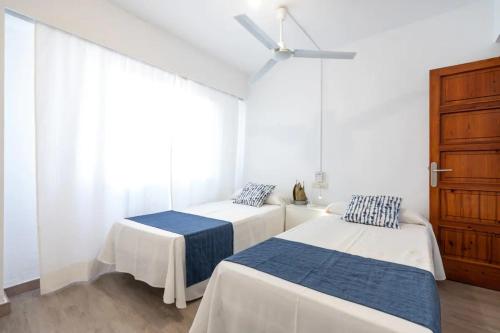 1 dormitorio con 2 camas y ventilador de techo en Apartamento Bel Planta Baja First Line Pinewalk, en Puerto Pollensa