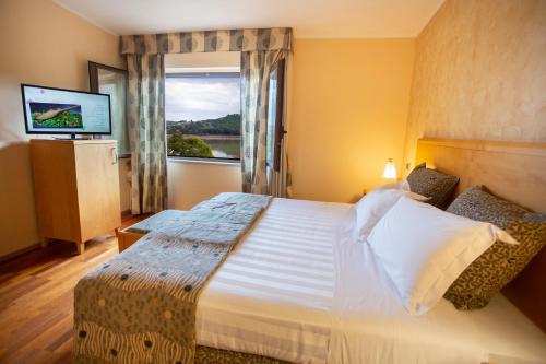 Habitación de hotel con cama grande y ventana en Riviera Hotel en Enna