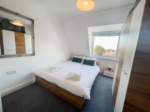 a small bedroom with a bed and a window at The Bridge Apartments in Lowestoft