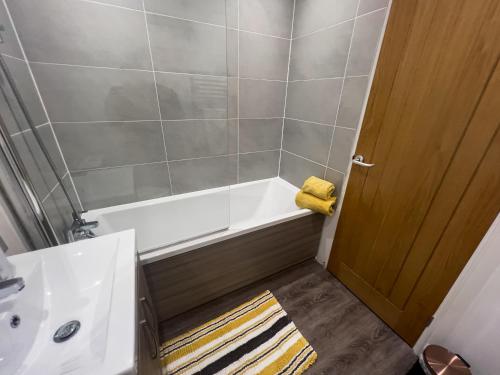 a bathroom with a bath tub and a sink at The Bridge Apartments in Lowestoft