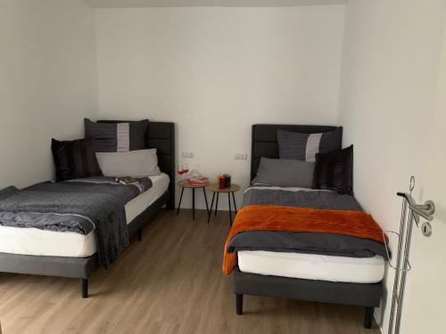 two beds sitting next to each other in a bedroom at Eifel24, neues und barrierefreies Appartement mit Terrasse in Schwirzheim
