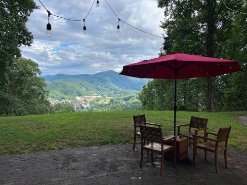 a table and chairs under a red umbrella at 2 Bedroom Apartment overlooks WCU and Cullowhee NC - Smoke and Pet free in Sylva
