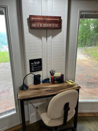 a desk with a chair and a sign on a window at 2 Bedroom Apartment overlooks WCU and Cullowhee NC - Smoke and Pet free in Sylva