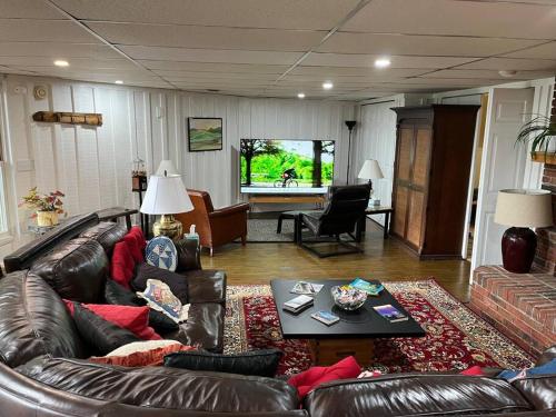 uma sala de estar com um sofá de couro e uma mesa em 2 Bedroom Apartment overlooks WCU and Cullowhee NC - Smoke and Pet free em Sylva