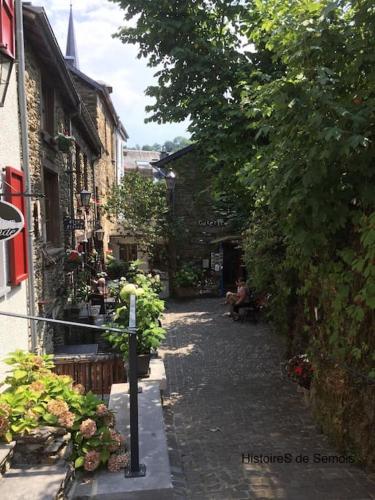 an alley with buildings and a person sitting on a bench at La Légende - Gîte dans un quartier pittoresque in Bouillon