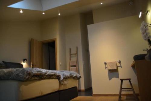 1 dormitorio con cama y escalera en la pared en La Légende - Gîte dans un quartier pittoresque, en Bouillon