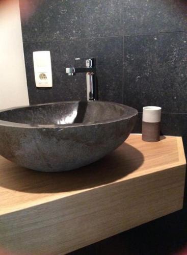a stone sink on a wooden counter in a bathroom at La Légende - Gîte dans un quartier pittoresque in Bouillon