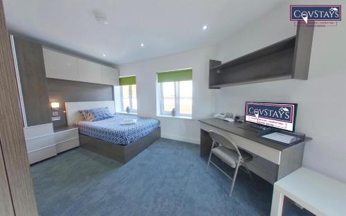 a room with a bed and a desk with a computer at New House - Magnificent Studios in Coventry City Centre, free parking, by COVSTAYS in Coventry