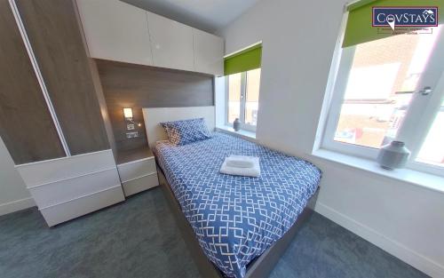 a bedroom with a bed with a pillow and a window at New House - Magnificent Studios in Coventry City Centre, free parking, by COVSTAYS in Coventry