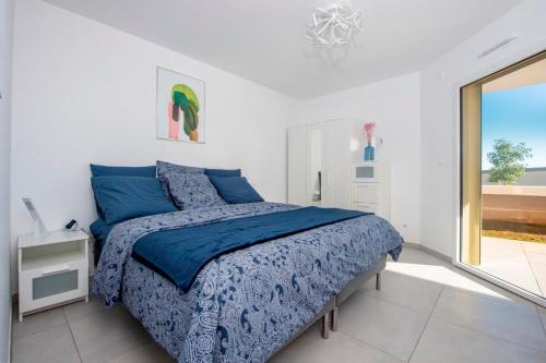 une chambre avec un lit avec des draps bleus et une fenêtre dans l'établissement Blue Pearl A008, à Nice
