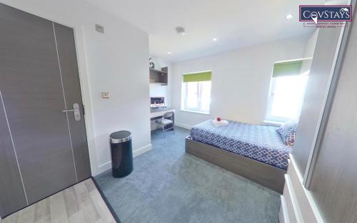 a small bedroom with a bed and a desk at New House - Magnificent Studios in Coventry City Centre, free parking, by COVSTAYS in Coventry