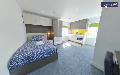 a large bedroom with a bed and a kitchen at New House - Magnificent Studios in Coventry City Centre, free parking, by COVSTAYS in Coventry