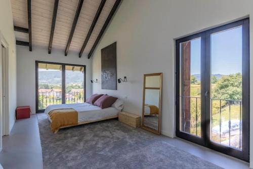 a bedroom with a bed and a large window at Larraetxea in Isla Becoa