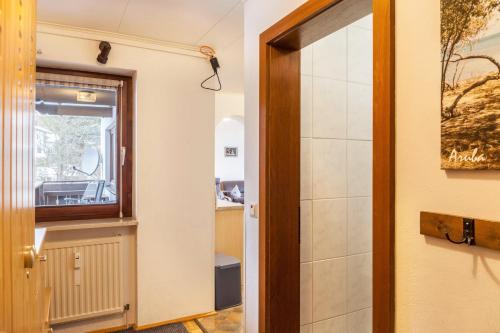 une porte menant à une salle de bains avec un miroir dans l'établissement Haus Excelsior Top 21, à Seefeld in Tirol