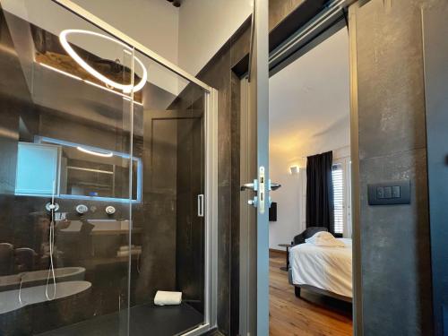 a bathroom with a glass shower and a bedroom at Gioiamia - Luxury Rooms in Cattedrale in Palermo