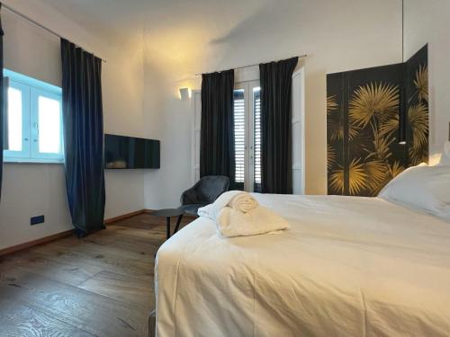 una camera da letto con un letto e un asciugamano sopra di Gioiamia - Luxury Rooms in Cattedrale a Palermo