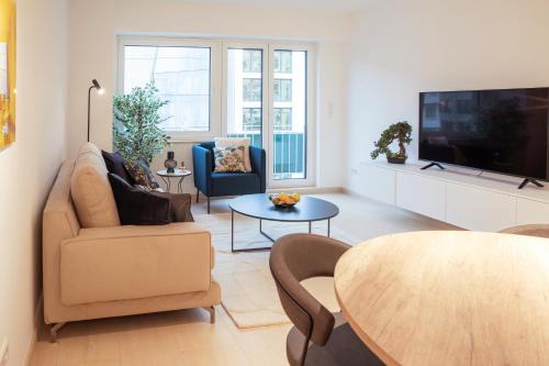 a living room with a couch and a tv at Hamilius Apartments City Center Luxembourg by Rentaroo in Luxembourg