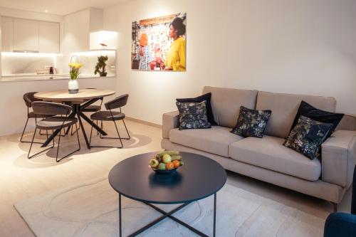 uma sala de estar com um sofá e uma mesa em Hamilius Apartments City Center Luxembourg by Rentaroo em Luxemburgo