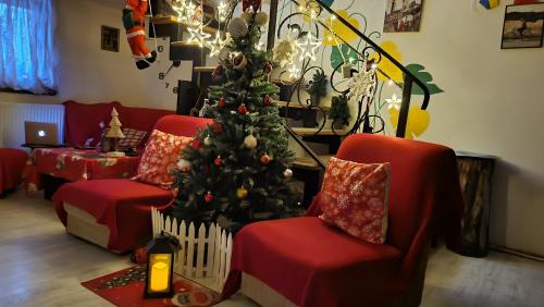 a living room with a christmas tree and red chairs at happy pandasN12 in Borjomi