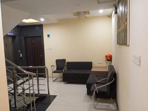 a living room with a couch and a stair case at Hotel Amigo in Ratlām