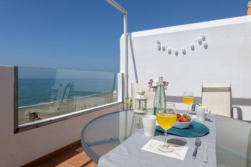 uma mesa com dois copos de vinho numa varanda em WintowinRentals Amazing Front Sea View & Relax em Torre de Benagalbón