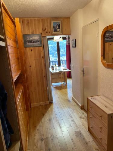 a room with a wooden floor and a room with a table at Appartement de vacances in Barcelonnette