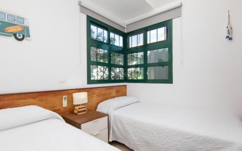 1 dormitorio con 2 camas y ventana en Bungalow Deluxe Las Palomas Maspalomas en Maspalomas